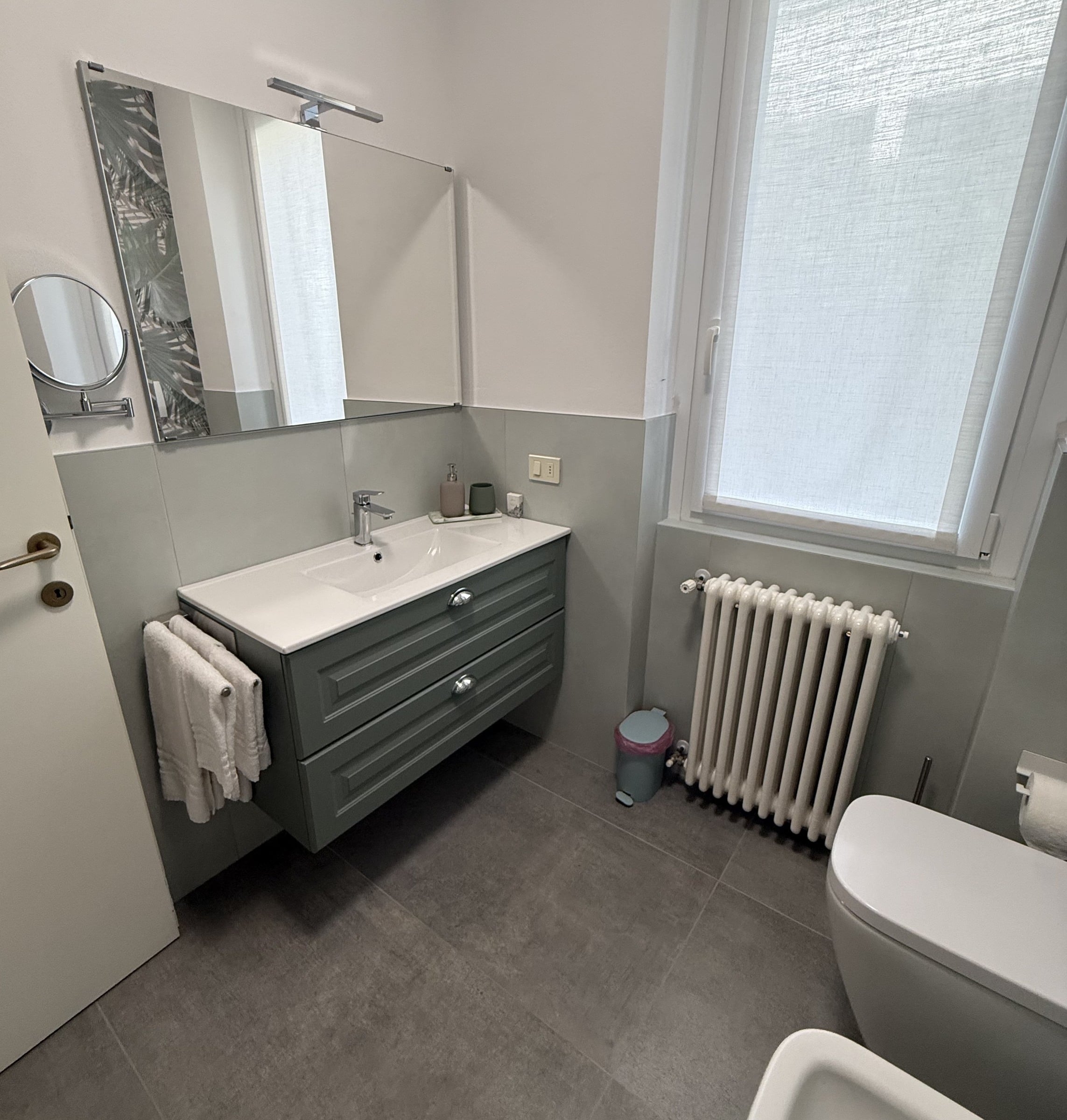 Second bathroom with a wide vanity, window, radiator, toilet and bidet